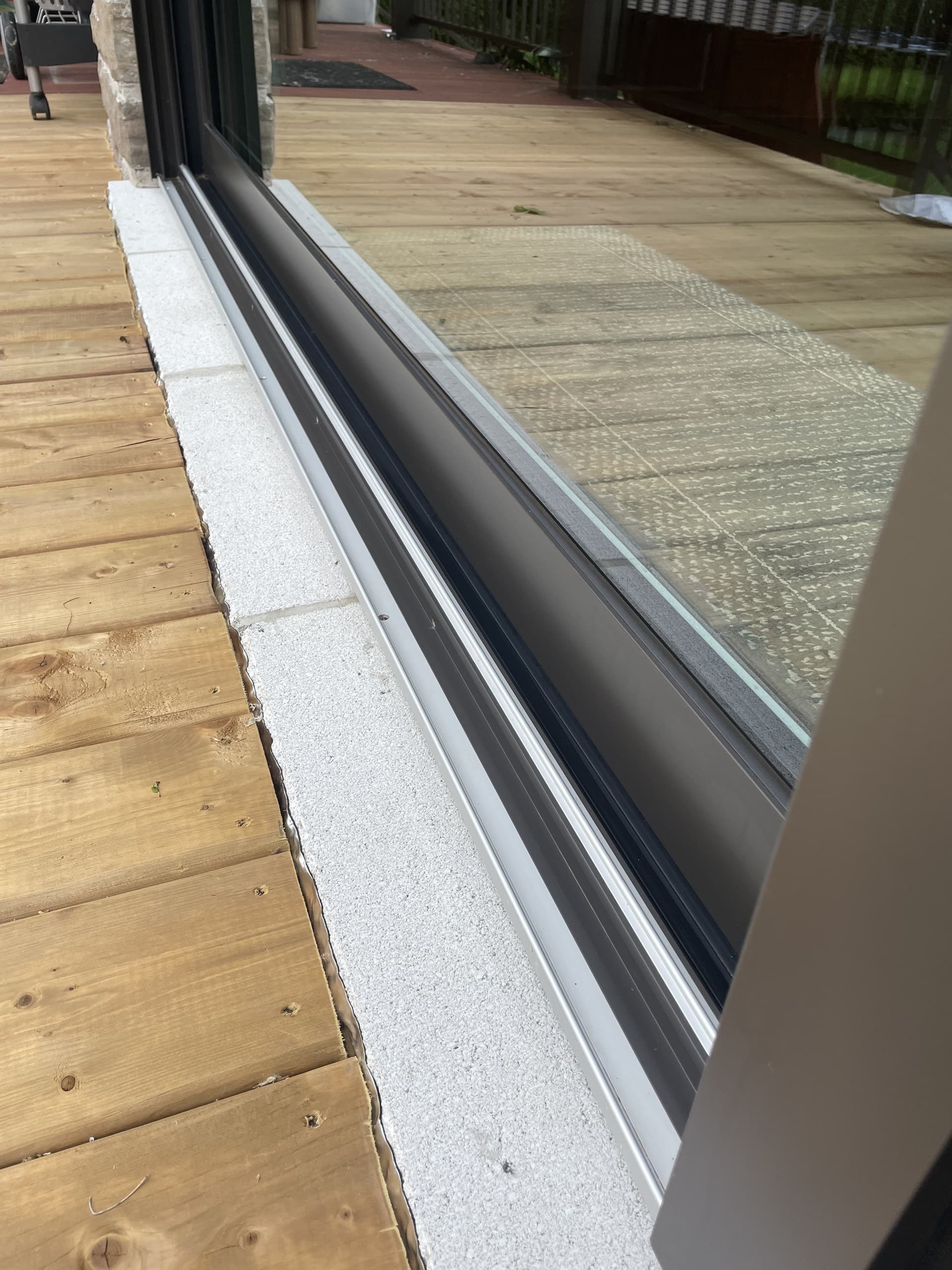 Close-up of a clean sliding glass door track with wooden patio